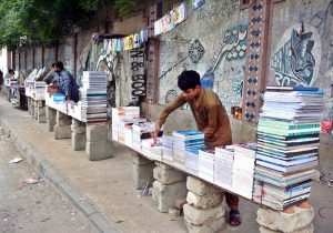 Roadside vendors display books and stationery for sale on cement blocks at the footpath near Urdu Bazaar.