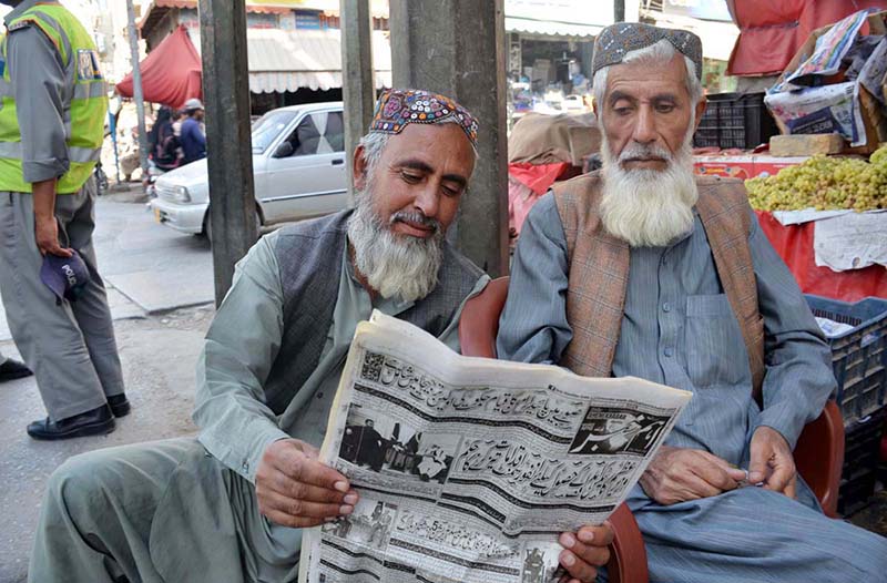 Elderly men read an Urdu newspaper to stay informed about current affairs and local,International, national and political issues at Liaquat Bazaar