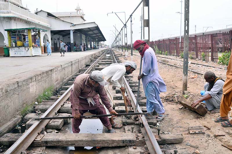 Railway workers repair tracks at the railway station to ensure safe train operations and prevent mishaps
