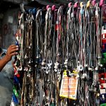 A roadside vendor arranges and displays mobile handsfree devices to attract customers in the provincial capital