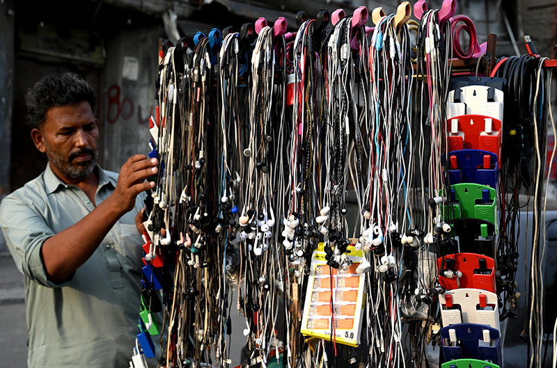 A roadside vendor arranges and displays mobile handsfree devices to attract customers in the provincial capital