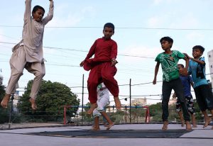 Children enjoying and jumping on trampoline along the roadside setup