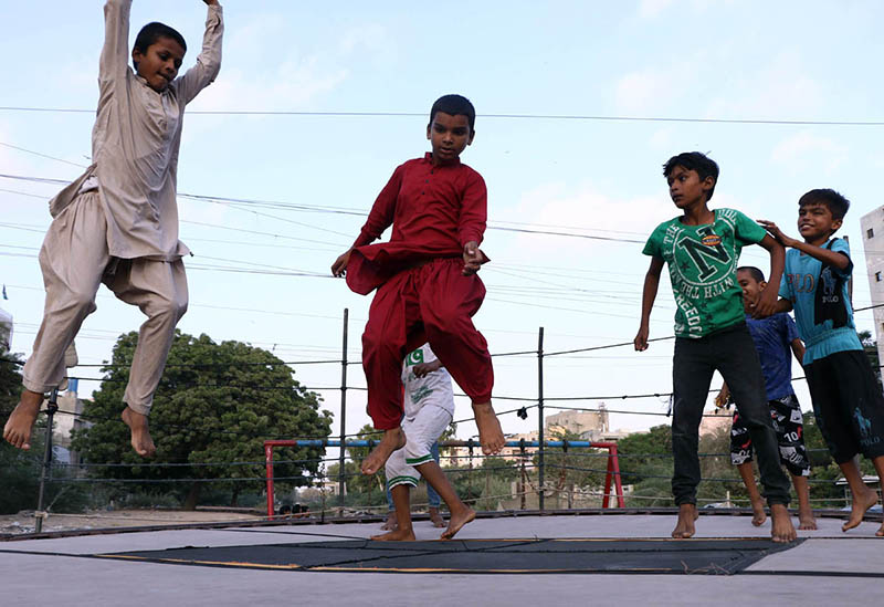 Report: Children enjoying and jumping on trampoline along the roadside setup