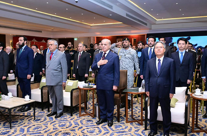 Prime Minister Muhammad Shehbaz Sharif and other dignitaries standing in respect while national anthems of China and Pakistan are played at a ceremony to celebrate the 77th anniversary of the founding of the People's Republic of China