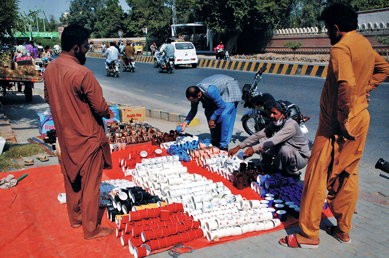Customers purchase tea cups at affordable prices from a roadside stall in the city