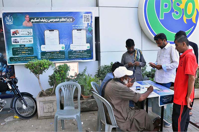 A large number of motorcyclists stand in a queue to receive tokens for subsidized petrol under the Prime Minister's Fuel Relief Scheme in Latifabad