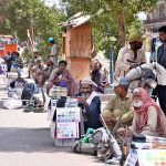 Daily wage workers having their tools, waiting for job at Latifabad Chowk