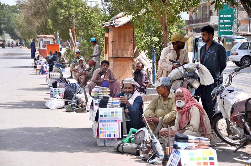 Daily wage workers having their tools, waiting for job at Latifabad Chowk
