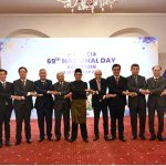 Federal Minister for Board of Investment Qaiser Ahmed Shaikh, Federal Minister for National Food Security and Research Rana Tanveer Hussain, Malaysian High Commissioner Dato' Mohammad Azhar Mazlan, and other dignitaries clasp hands in a gesture of solidarity, posing together as Malaysia's 69th National Day is celebrated at a local hotel