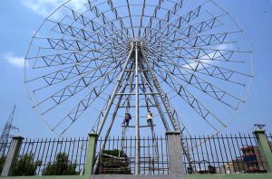 Laborers busy with installation of Ferris wheel at historic Jinnah Park.