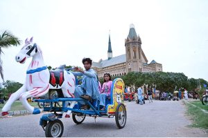 Children enjoy a horse-shaped tricycle ride at Frere Hall Park for pleasure.