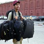 Street vendor displaying bags to attract the customers while shuttling on the road in Provincial Capital