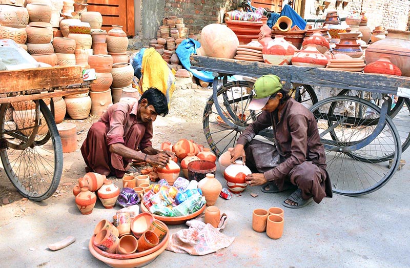 Workers are busy coloring the clay-made pots for selling at Kumhar Para