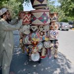 A street vendor displaying hand-made domestic use items to attract customers at roadside in F-10 Markaz