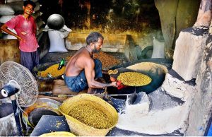 A man roasts chickpeas (black chana) at his workplace.