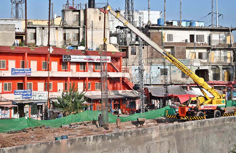 Heavy machinery, including excavators and cranes, is deployed at the service road construction site along the Expressway as development work continues to improve the road infrastructure in the Federal Capital