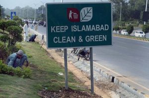 CDA workers tend to the green belt along Srinagar Highway in the Federal Capital.
