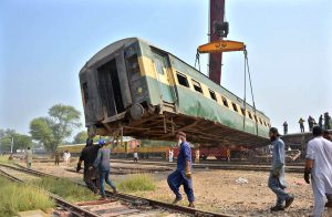 A crane lifts a derailed coach of the Rehman Baba Express during rescue and recovery operations near Sher Shah Railway Station at least four passengers were killed and 49 injured in the incident.