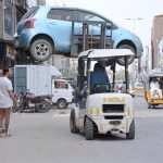 Traffic warden removing the wrong parked car with the help of a forklift
