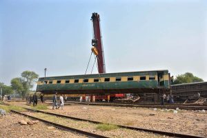 A crane lifts a derailed coach of the Rehman Baba Express during rescue and recovery operations near Sher Shah Railway Station at least four passengers were killed and 49 injured in the incident.