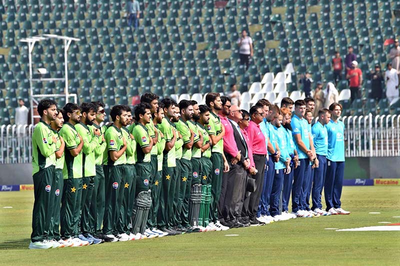 Players of the Pakistan and England cricket teams stand in respect of the national anthems of both countries before the start of the match during the ODI Tri-Nation Series at Rawalpindi Cricket Stadium