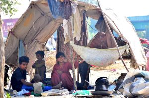 A gypsy woman busy in washing pots outside her hut at Makki Shah area