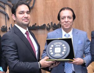 President Chamber of Commerce, Khawar Hussain Sapal, is presenting a souvenir to Provincial Minister for Energy, Sports, and Youth Affairs, Faisal Ayub Khokhar, at SCCI