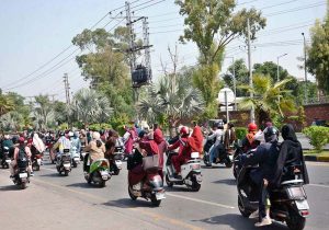 Women participate in a road safety awareness scooter rally organized by the Road Safety Club at the University of Agriculture Faisalabad in collaboration with City Traffic Police