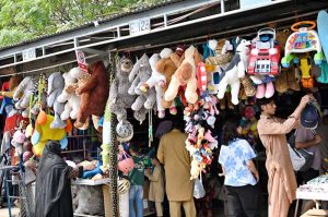 A woman is selecting and purchasing shoes from a stall in Sunday Bazaar at Peshawar Mor in the Federal Capital