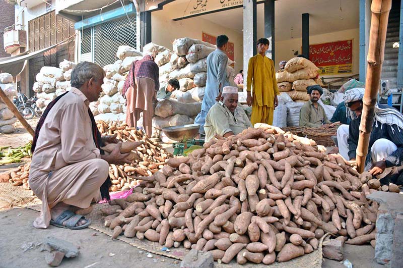 A vendor displaying sweet potatoes to attract the customer at Vegetable Market