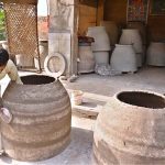 A potter gives the final shape and finishing touches to a traditional tandoor at his workplace near Railway Chowk