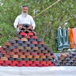 A roadside vendor displays caps to attract customers at his stall