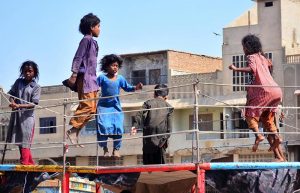 Young girls enjoy a playful moment on a jumping jack on a trampoline in the Old Sabzi Mandi area.