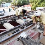 Railway workers busy in maintenance work on the railway track bridge near Municipal Higher Secondary School