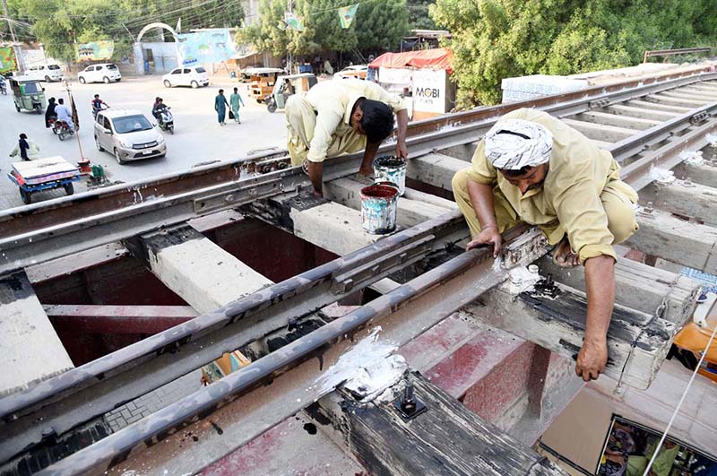 Railway workers busy in maintenance work on the railway track bridge near Municipal Higher Secondary School
