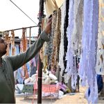 A stallholder displays different laces to embellish clothes at the PWD Sunday Bazaar