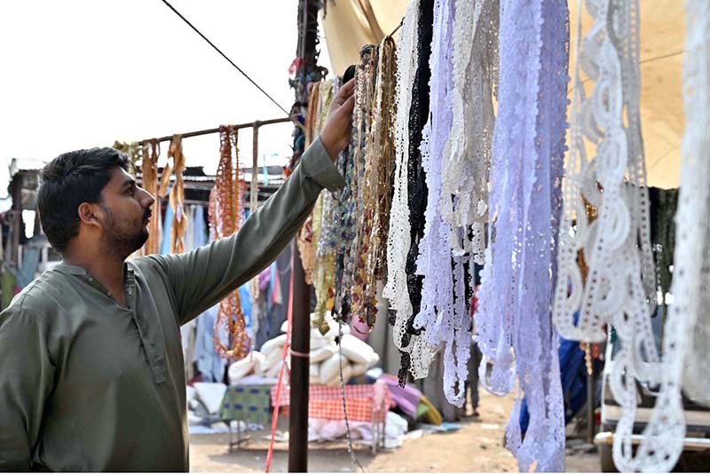 A stallholder displays different laces to embellish clothes at the PWD Sunday Bazaar