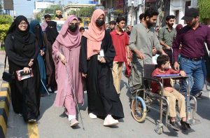 Participants march during an awareness walk organized by the Eilya Care Foundation to mark World White Cane Safety Day at D-Ground Chowk.