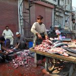 Workers clean fish for customers at a local fish market in the city