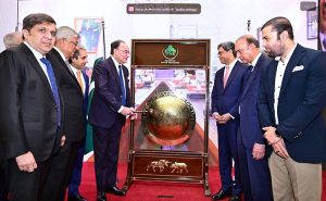 Federal Minister for Finance and Revenue Senator Muhammad Aurangzeb rings the gong during a ceremony at the Trading Hall of the Pakistan Stock Exchange (PSX)