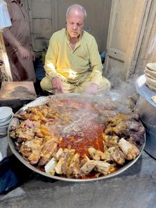 A vendor prepares traditional breakfast Siri Paye (trotters and head meat) near Bhati Gate