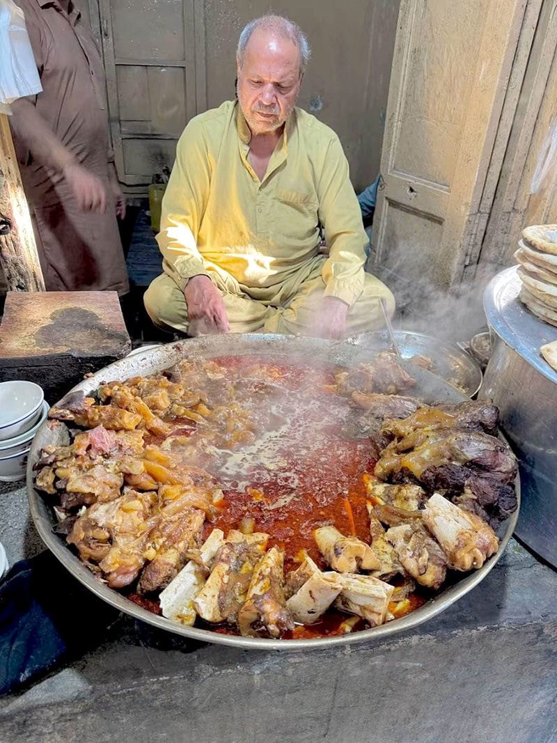 A vendor prepares traditional breakfast Siri Paye (trotters and head meat) near Bhati Gate