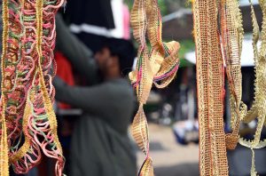 A stallholder displays different laces to embellish clothes at the PWD Sunday Bazaar