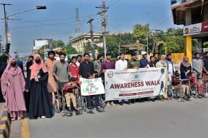 Participants march during an awareness walk organized by the Eilya Care Foundation to mark World White Cane Safety Day at D-Ground Chowk.
