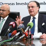 Federal Minister for Finance and Revenue Senator Muhammad Aurangzeb, accompanied by Adviser to the Finance Minister Khurram Schehzad, talks to media persons after a meeting at the Overseas Investors Chamber of Commerce and Industry (OICCI) office