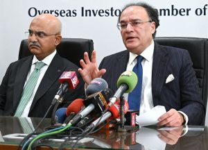 Federal Minister for Finance and Revenue Senator Muhammad Aurangzeb, accompanied by Adviser to the Finance Minister Khurram Schehzad, talks to media persons after a meeting at the Overseas Investors Chamber of Commerce and Industry (OICCI) office