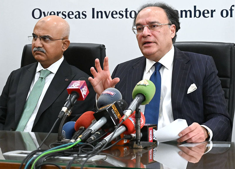 Federal Minister for Finance and Revenue Senator Muhammad Aurangzeb, accompanied by Adviser to the Finance Minister Khurram Schehzad, talks to media persons following a meeting at the Overseas Investors Chamber of Commer