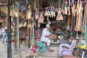 A traditional wooden slingshot maker prepares and decorates handmade slingshots at his shop, showcasing a centuries-old local craft.