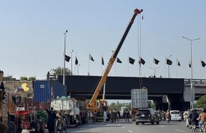 A crane lifts a container as authorities remove containers from the entry and exit routes of Federal Capital, on the administration’s orders.