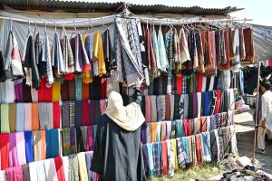 Vendors displaying shoes to attract the customers at stall in Sunday Bazaar
